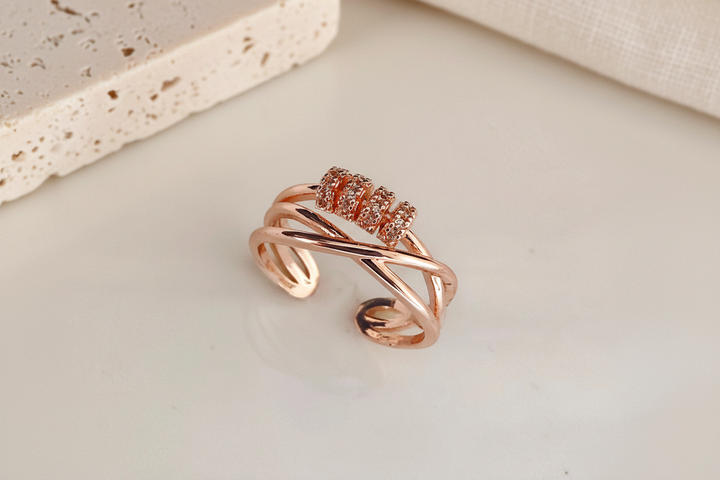 Rose gold ring with small diamonds on a white ceramic plate